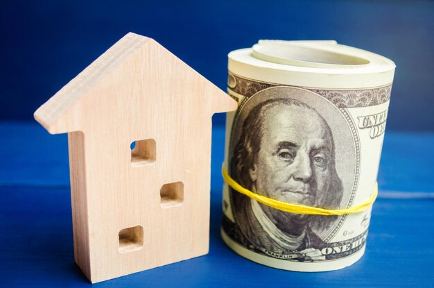 Holzhaus und Dollar auf blauem Hintergrund Konzept des Immobilienkaufs Verkaufs Vermietung