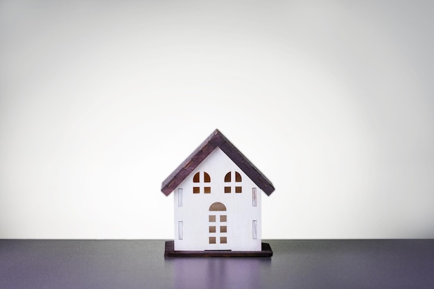 Holzhausmodell auf hellgrauem Hintergrund Immobilienkonzept
