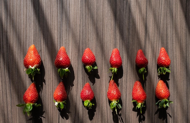 Foto holzhintergrund für text mit roten frischen und reifen erdbeeren sommerdekoration aus beeren