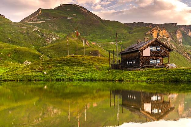 Holzhütte am See in den Hochalpen bei Sonnenaufgang im Sommer