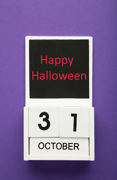 Holzkalender mit dem Datum vom 31. Oktober auf violettem Hintergrund Happy Halloween