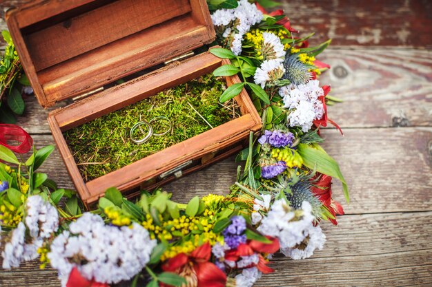 Holzkiste mit Eheringen in den Blumen