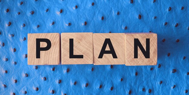 Holzklötze mit dem Text Plan auf rotem Lederhintergrund Business Planning Management Concept