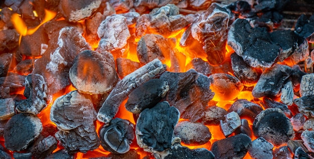 Foto holzkohle und glut, die in einem metallgrill auf hochtouren brennen