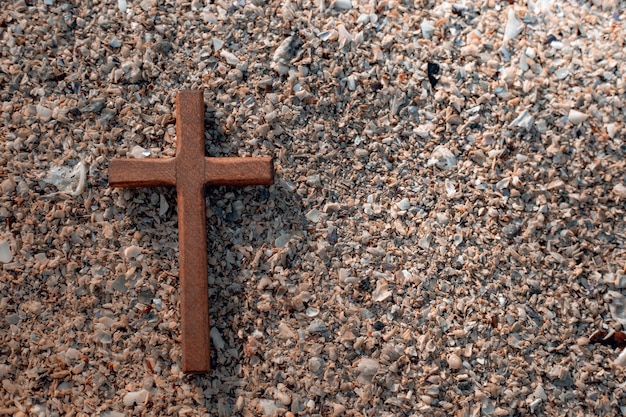 Holzkreuz auf Steinhintergrund.