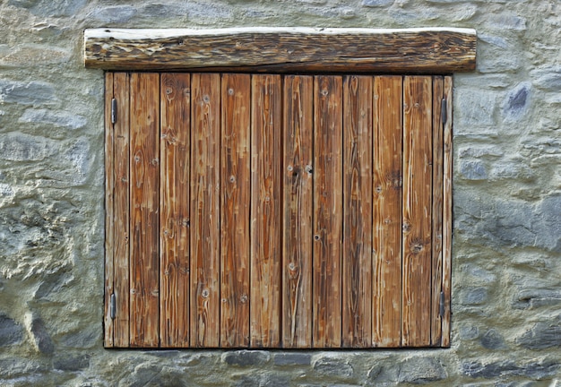 Holzläden an einer Steinfassade eines Bergchalets geschlossen