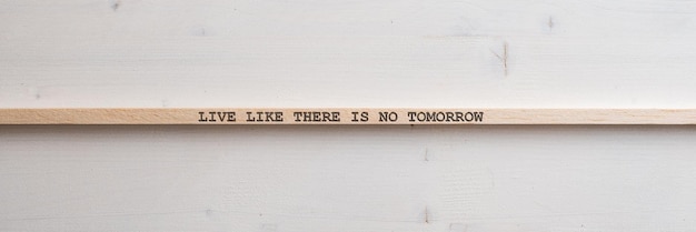 Holzlatte mit einem Live like there is no tomorrow-Schild darauf
