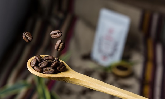 Foto holzlöffel mit fallenden kaffeebohnen