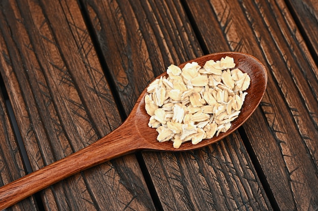 Holzlöffel mit Haferflocken auf einem Holzbrett