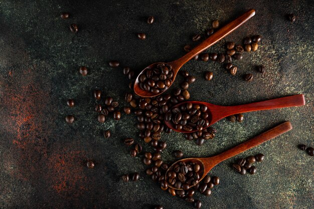 Holzlöffel voll kopi luwak Kaffeebohnen auf Dunkelheit