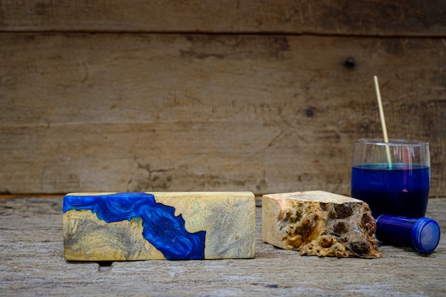 Holzmaserholzhackschnitzel Farbflasche und Harzepoxid zum Gießen von Holz auf altem Holztischhintergrund