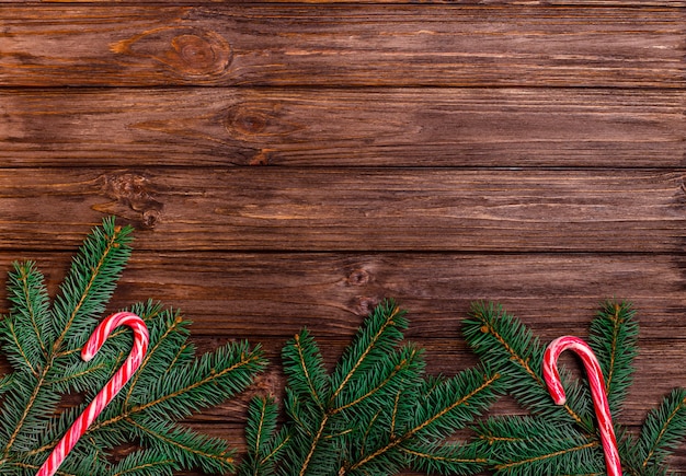 Holzoberfläche mit Tannenzweigen und Zuckerstangen