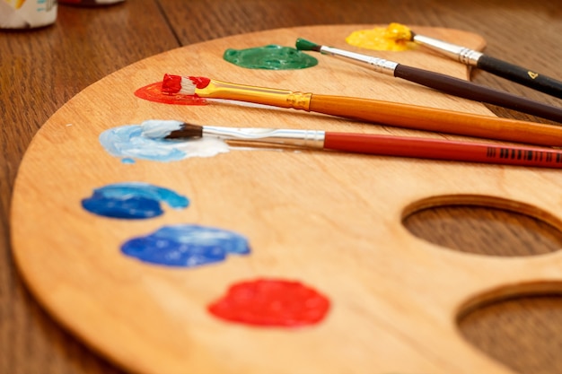 Holzpalette mit dem Auftragen von Farben und Pinseln auf dem Tisch