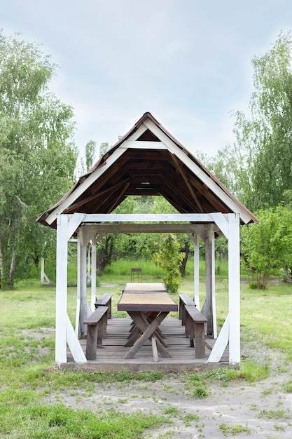 Holzpavillon im Freien im Sommergarten Holzlaube auf grünem Rasen für Erholung im Freien Camping