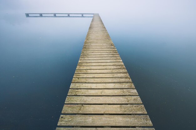 Foto holzpfeiler am see gegen den himmel