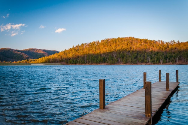 Holzpfeiler über dem See gegen den Himmel