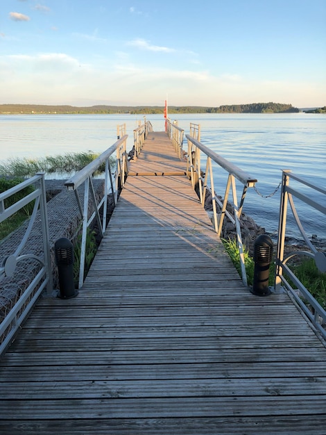 Holzpier, der gegen den Himmel zum Meer führt