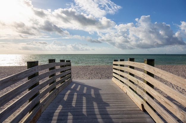 Holzplattform an einem Sandstrand an einem sonnigen Tag