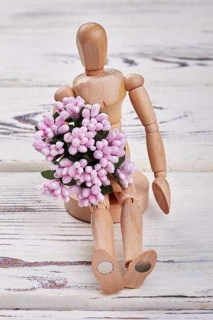 Holzpuppe mit Blumen Einfache Überraschung für die Frau