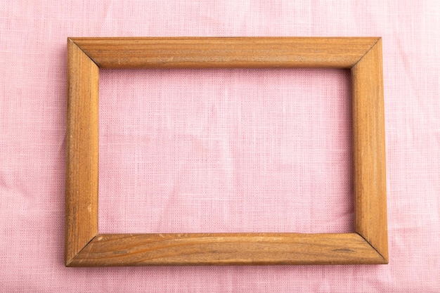 Holzrahmen auf glattem rosafarbenem Leinengewebe Draufsicht natürlicher Textilhintergrund