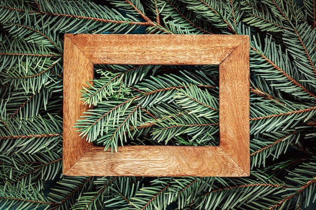 Holzrahmen auf Weihnachtsbaumzweigen Texturhintergrund