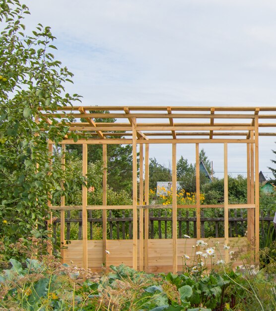 Holzrahmenbau einer neuen Veranda oder eines Pavillons auf dem Territorium eines Landgrundstücks, im Sommer im Freien.