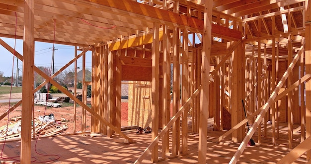 Holzrahmengebäude im Bau in einem Vorort mit neuen Stabbalken, die mit einer Wand gebaut wurden