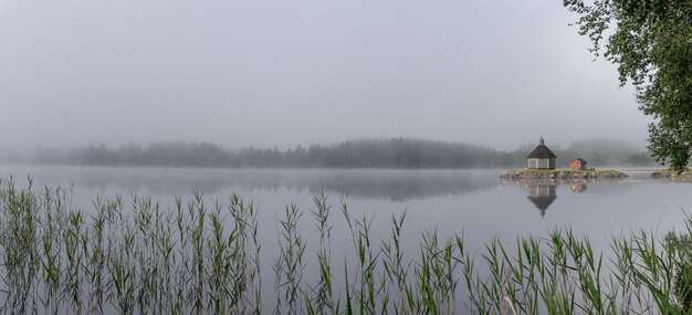 Holzsauna im Nebel am frühen Morgen auf dem See Gaxsjon, Schweden