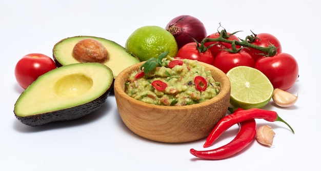 Holzschale mit Guacamole-Dip-Sauce und Zutaten isoliert auf weißem Hintergrund