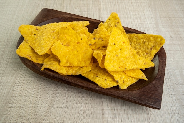 Holzschale mit Tortillas auf hellem Holztisch.