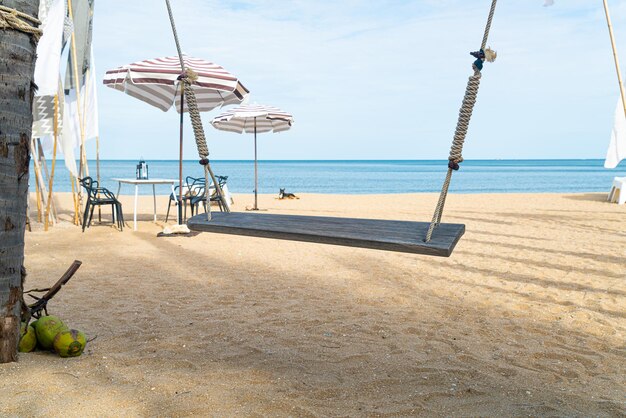 Holzschaukel am Strand mit Meeresstrand Hintergrund