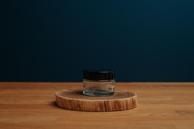 Holzscheibe mit leerem Glas für Kosmetikpräsentation