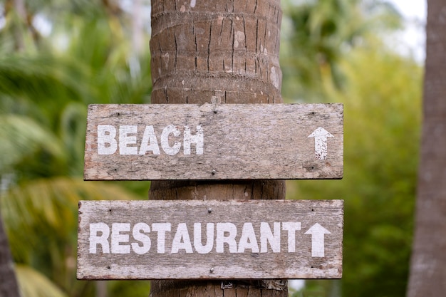 Holzschild am tropischen Strand mit Wegbeschreibung. Thailand