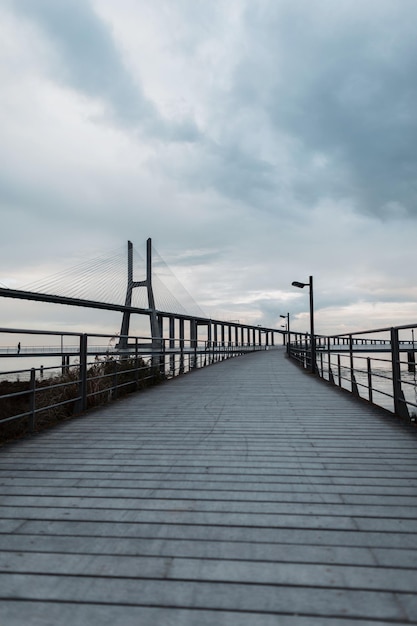 Holzsteg mit Brücke an einem bewölkten Tag mit Wolken