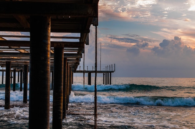 Holzsteg vor dem Hintergrund des Sonnenuntergangs und des Meeres