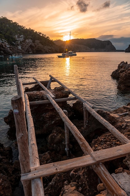 Holzstege am Strand bei Sonnenuntergang in Benirras im Ibiza-Urlaubskonzept