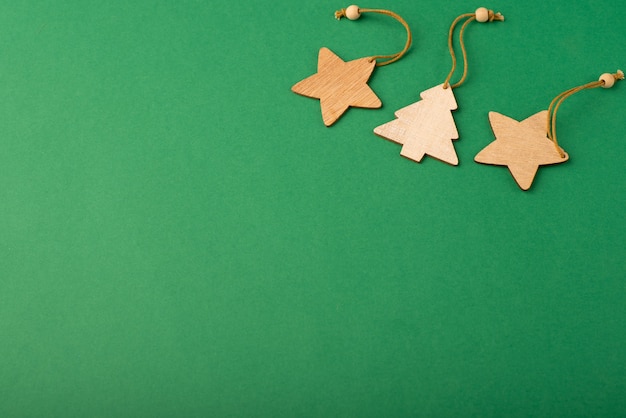 Holzsterne und Weihnachtsbaum auf grünem Hintergrund mit goldenen Sternen