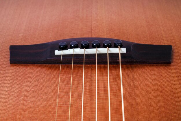 Holzstruktur des unteren Decks der sechssaitigen Akustikgitarre auf weißem Hintergrund Gitarrenform