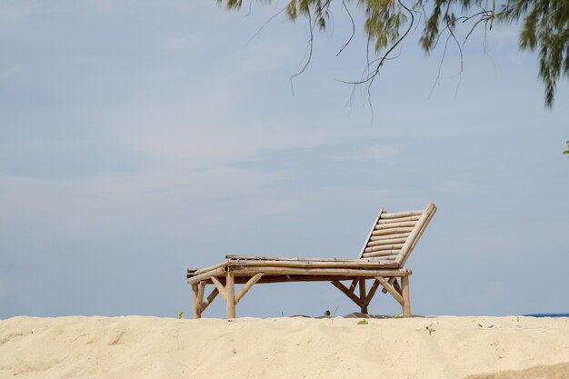 Holzstuhl auf dem Sandstrand für Sommerkonzept