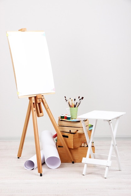 Holzstuhl mit sauberem Papier und Kunstgegenständen im Zimmer