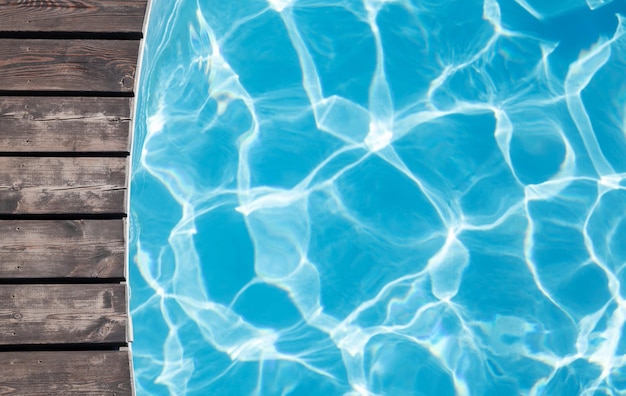 Holzterrasse am Pool und blaues Wasser des Pools