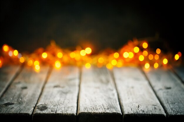 Holztisch auf Weihnachtslichthintergrund Bokeh