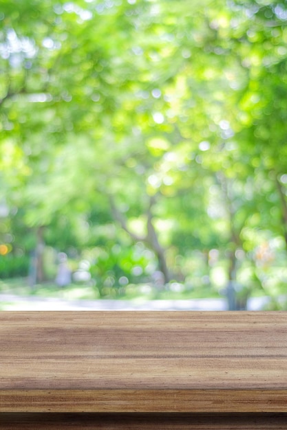 Holztisch für die Anzeige von Lebensmitteln über unscharfem grünen Gartenhintergrund