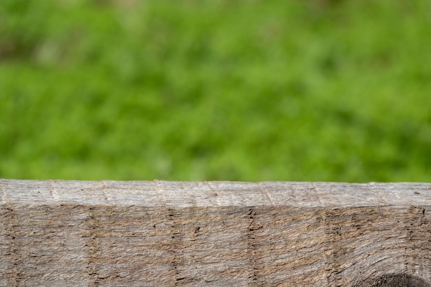 Foto holztisch grüner wandhintergrund mit sonnenlichtfenster erzeugen blattschatten an der wand mit unscharfer grüner innenpflanze im vordergrundpanorama-banner-mockup für die anzeige des produktumweltfreundlichen innenkonzepts