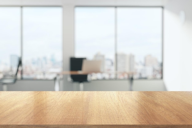 Foto holztisch im sonnigen büro mit großen fenstern