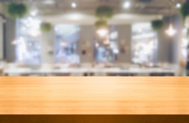 Holztisch im verschwommenen Hintergrund des modernen Restaurantraums oder des Kaffeehauses für Produktanzeigemodell