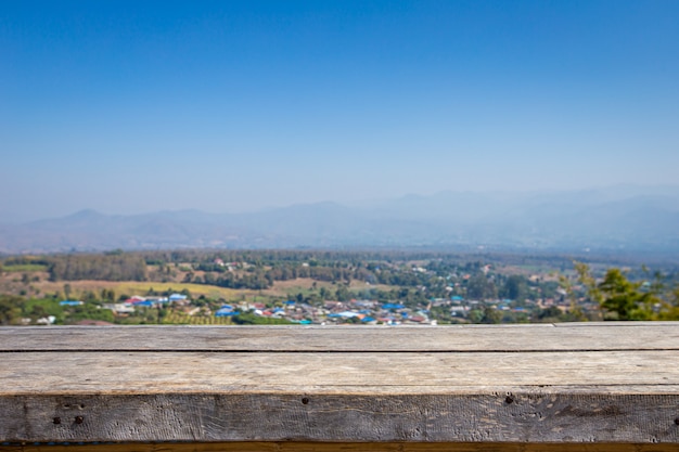 Holztisch mit Blick auf das ländliche Dorf und die Berge