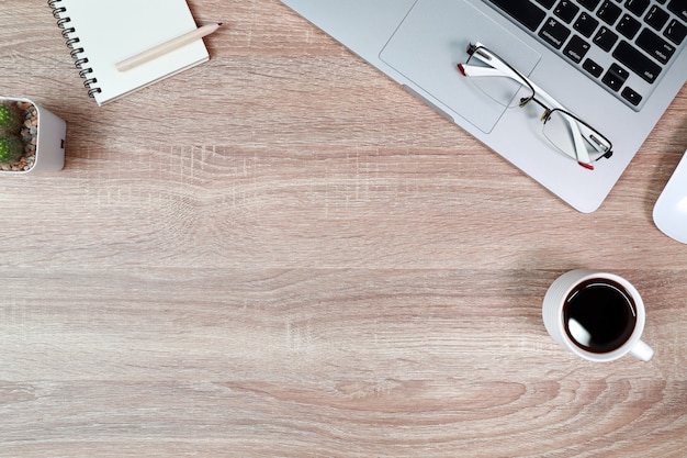 Holztisch mit Laptop-Computer und schwarzer Kaffeetasse