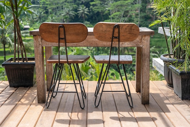 Holztisch und Stühle in einem leeren tropischen Café neben Reisterrassen auf der Insel Bali Indonesien