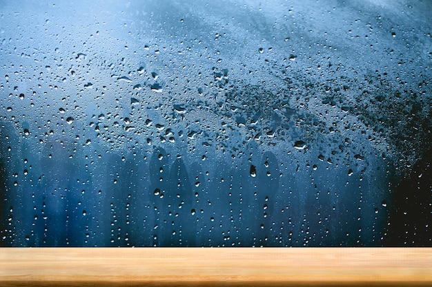 Holztischbodenplattform mit Regentropfen auf Fensterglas Draufsicht auf Plankenholz für die Innenausstattung von grafischen Standprodukten oder die Montage Ihres Produkts